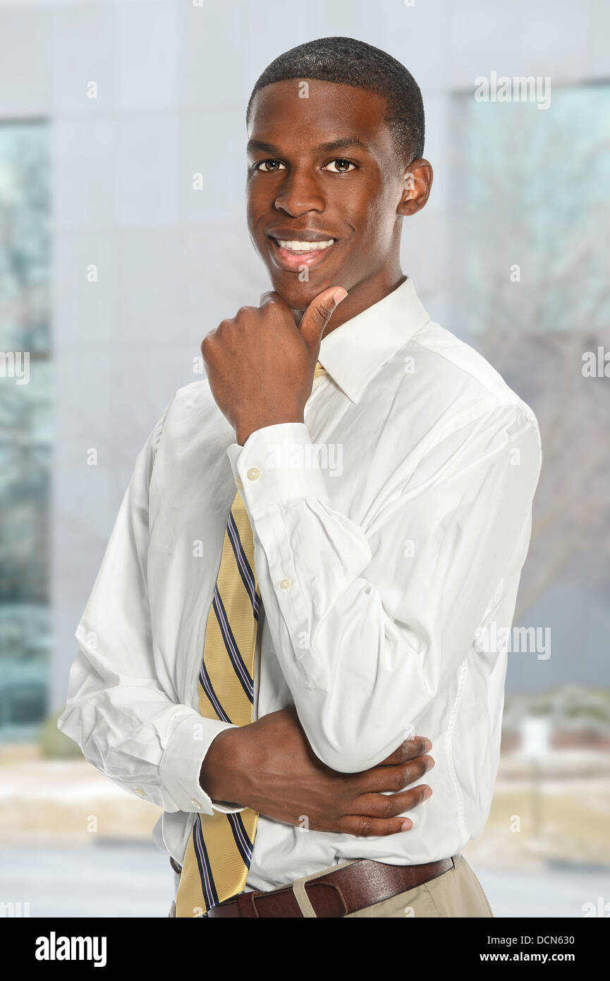 Portrait of young African American businessman with office building in ...