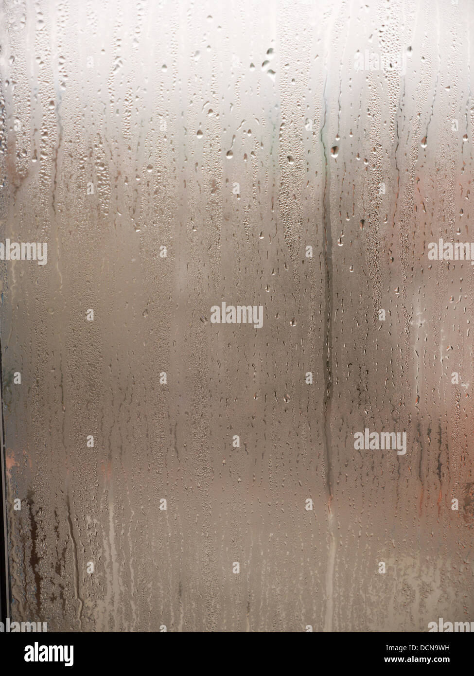 Heavy condensation runs down a window Stock Photo