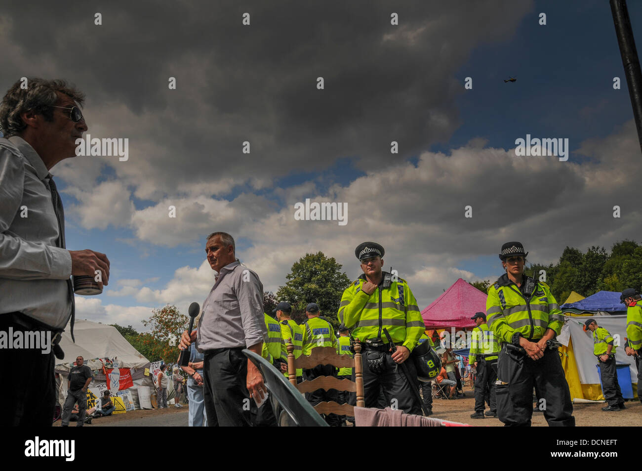 BBC'S Mark Norman prepares to go on air as helicopter hovers over Cuadrilla site entrance in Balcombe, West Sussex, UK Stock Photo