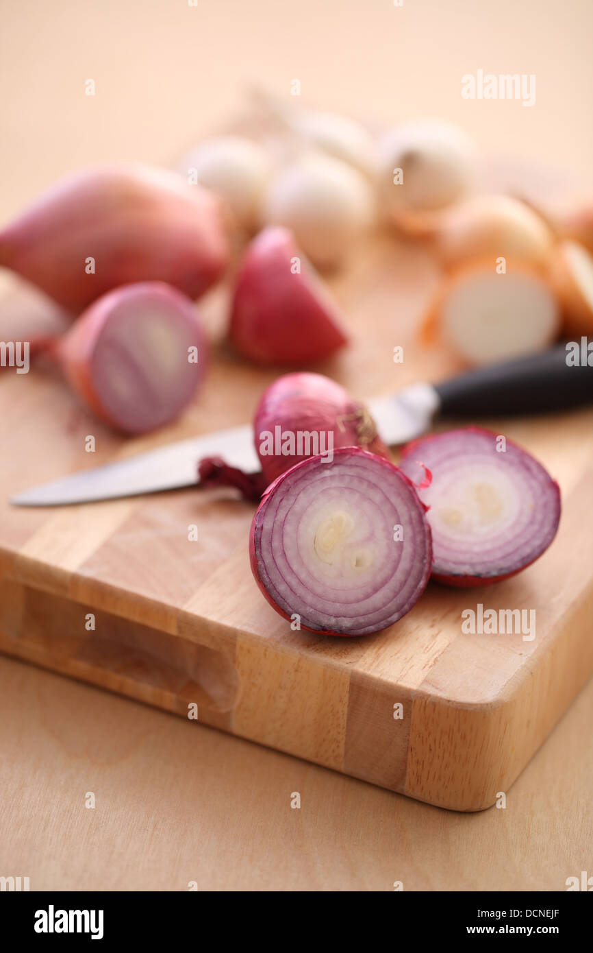 Assortment of Onions and Shallots on cutting board Stock Photo