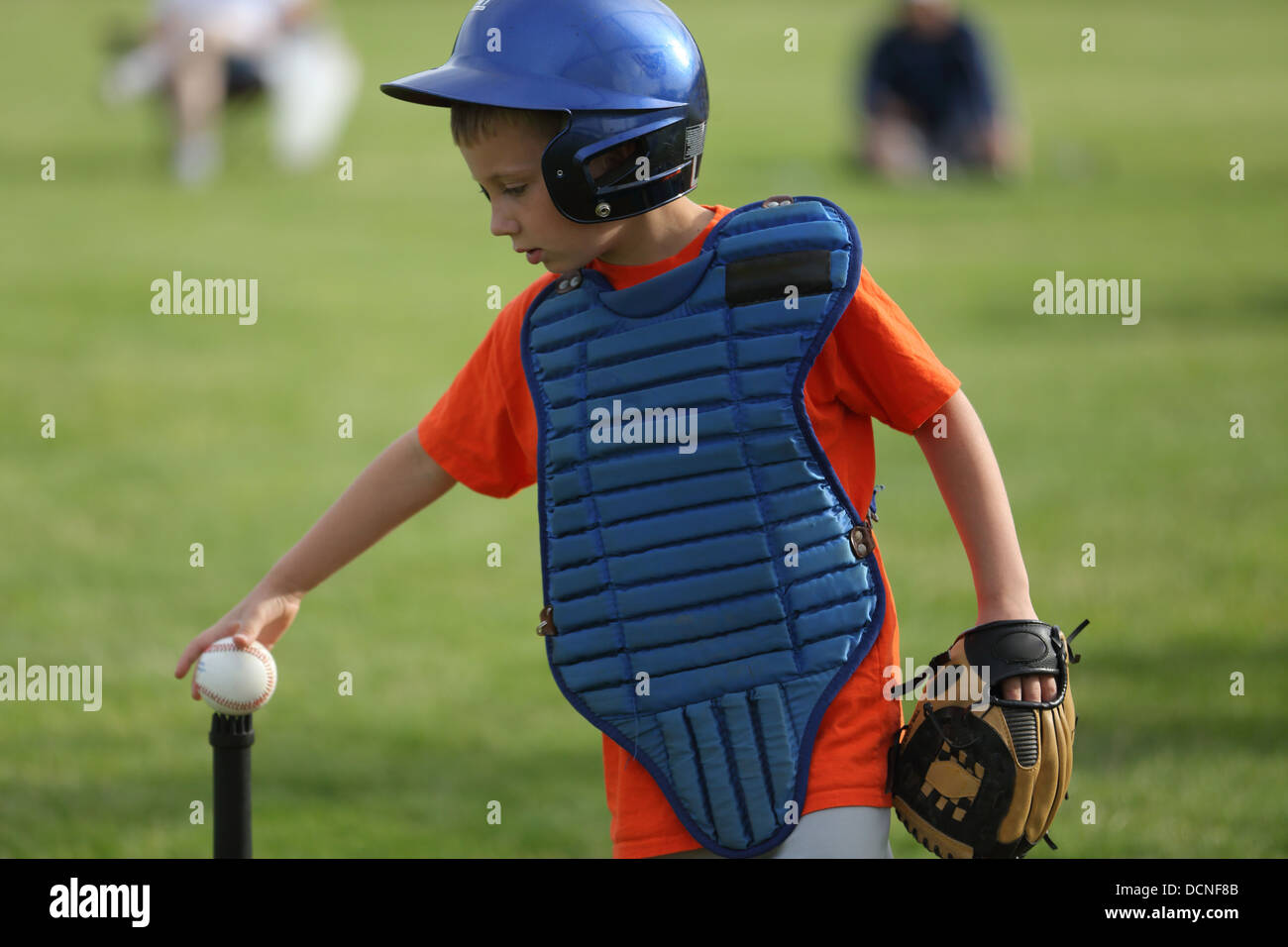 Young boy puts baseball on tee Stock Photo