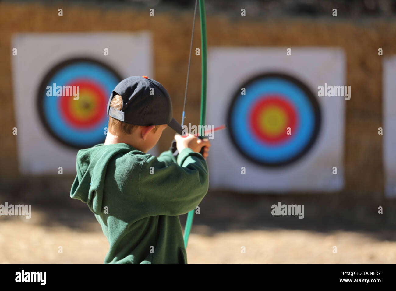 Young boy pointing arrow at target Stock Photo