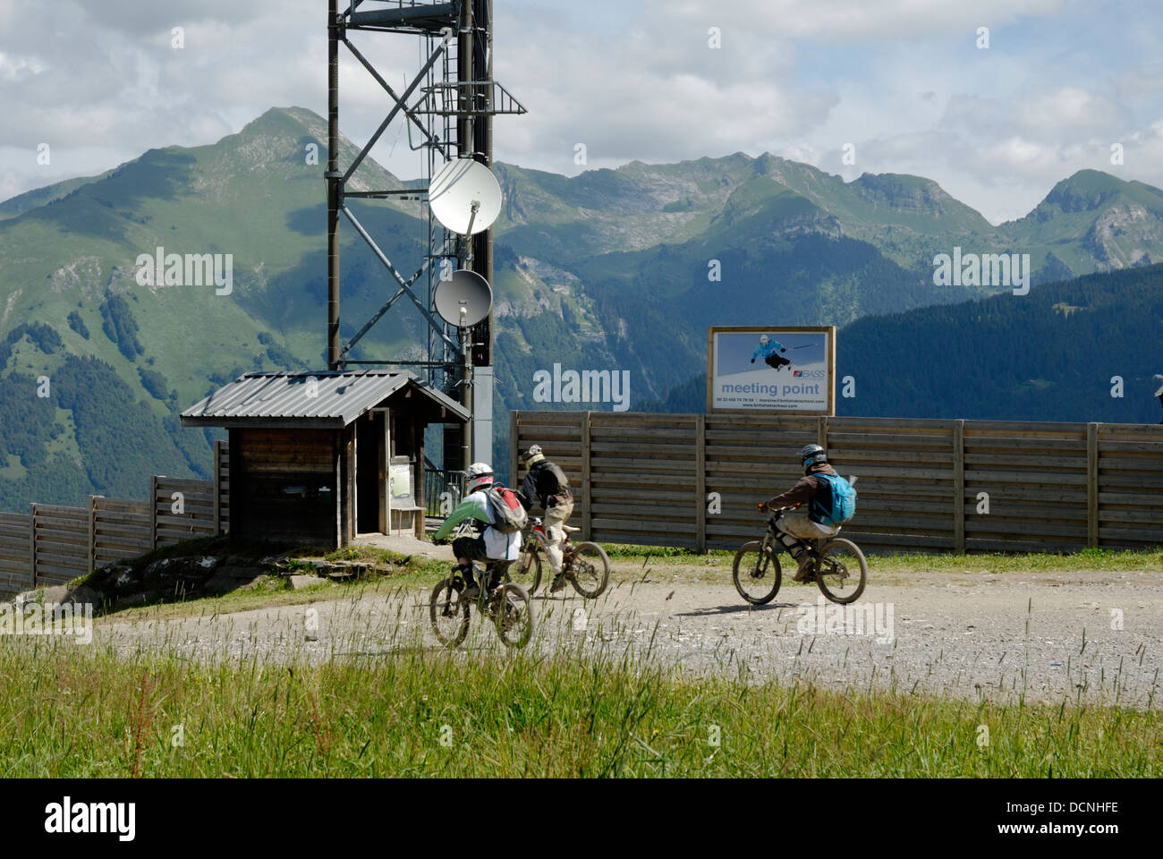 Mountain bikers, setting off with mountains behind in the French alps, Summer time, France Stock Photo