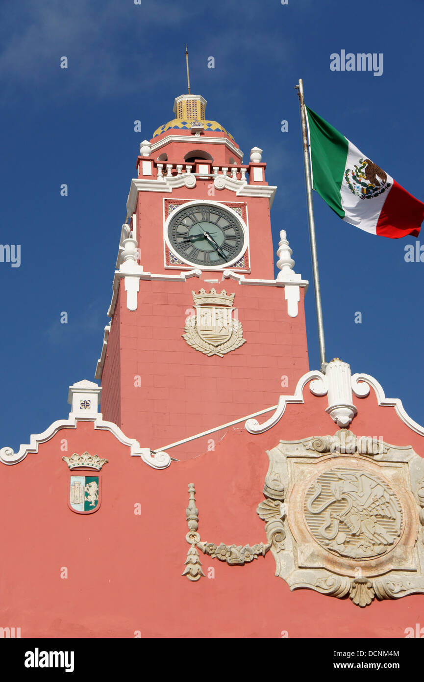 Clock tower of the Municipal Palace or Palacio Municipal and billowing Mexican flag, Merida, Yucatan, Mexico Stock Photo