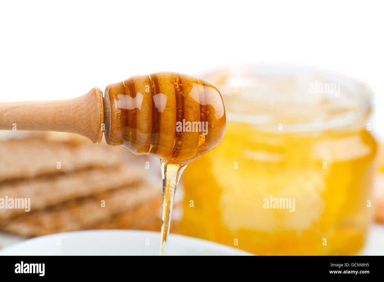 Honey dripping from wooden stick Stock Photo Alamy