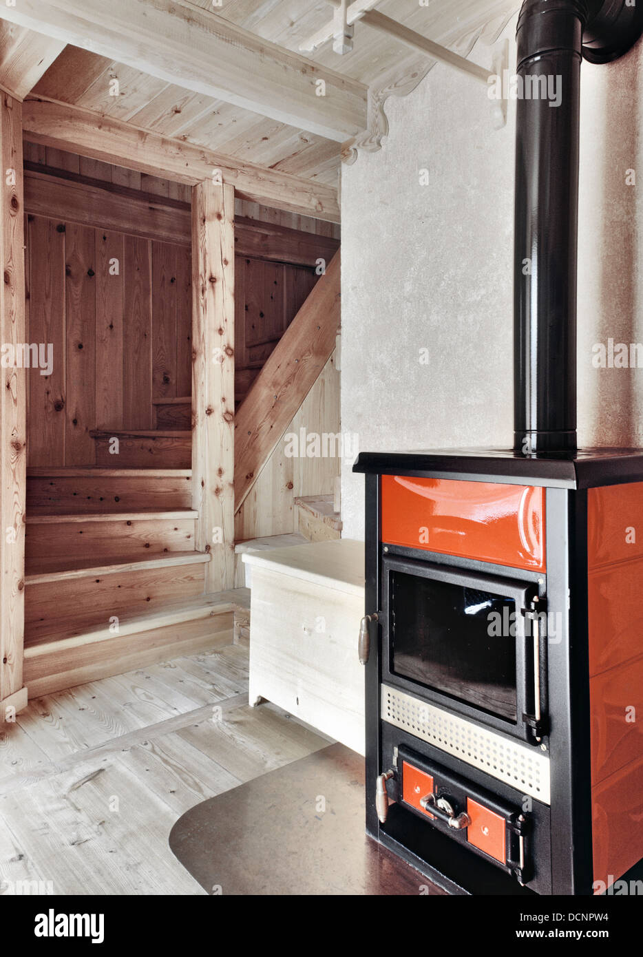 Red Stove Near To Rustic Wood Staircase With Wood Ceiling