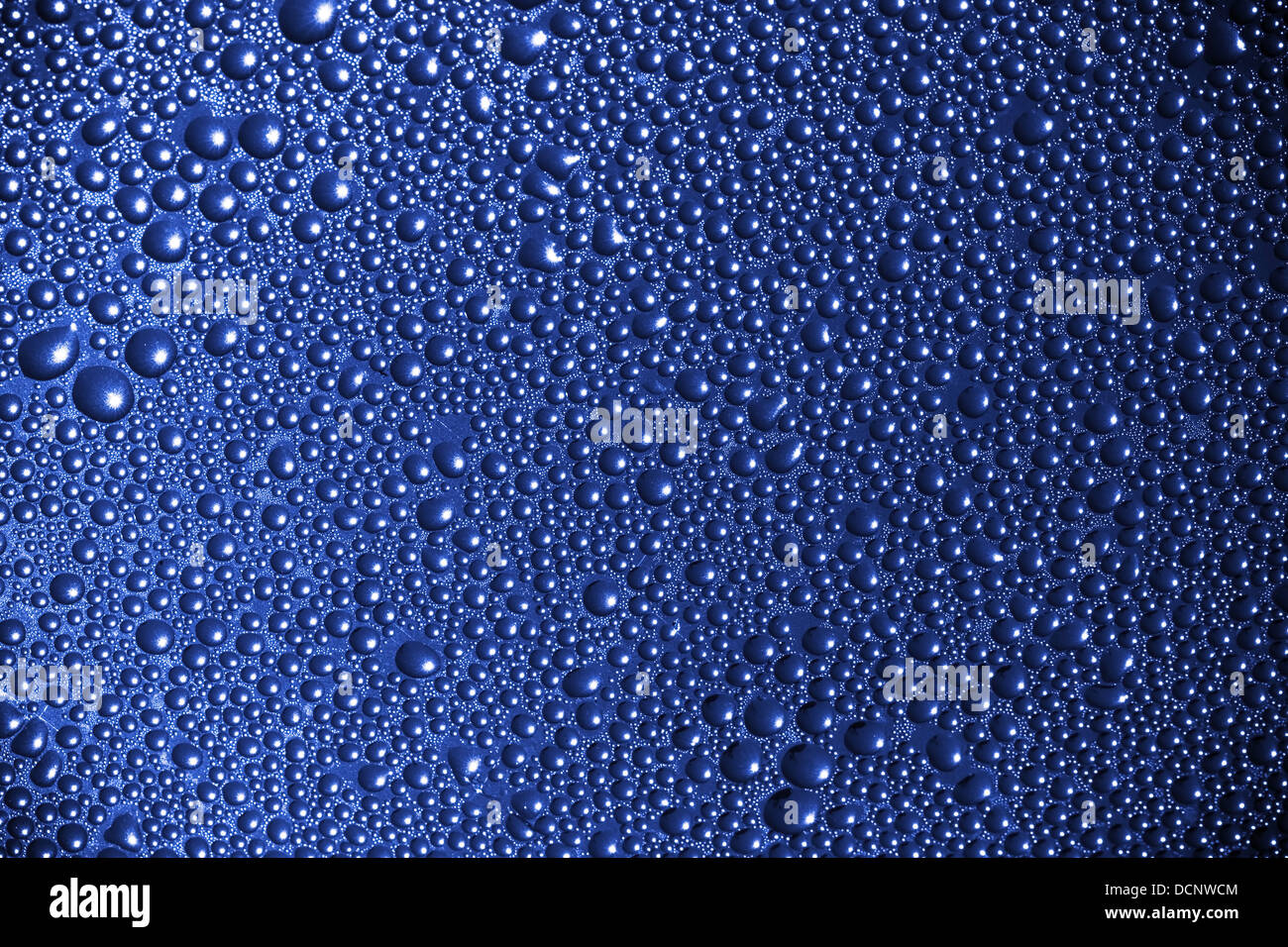 Abstract macro background with deep blue wet surface and water drops Stock Photo