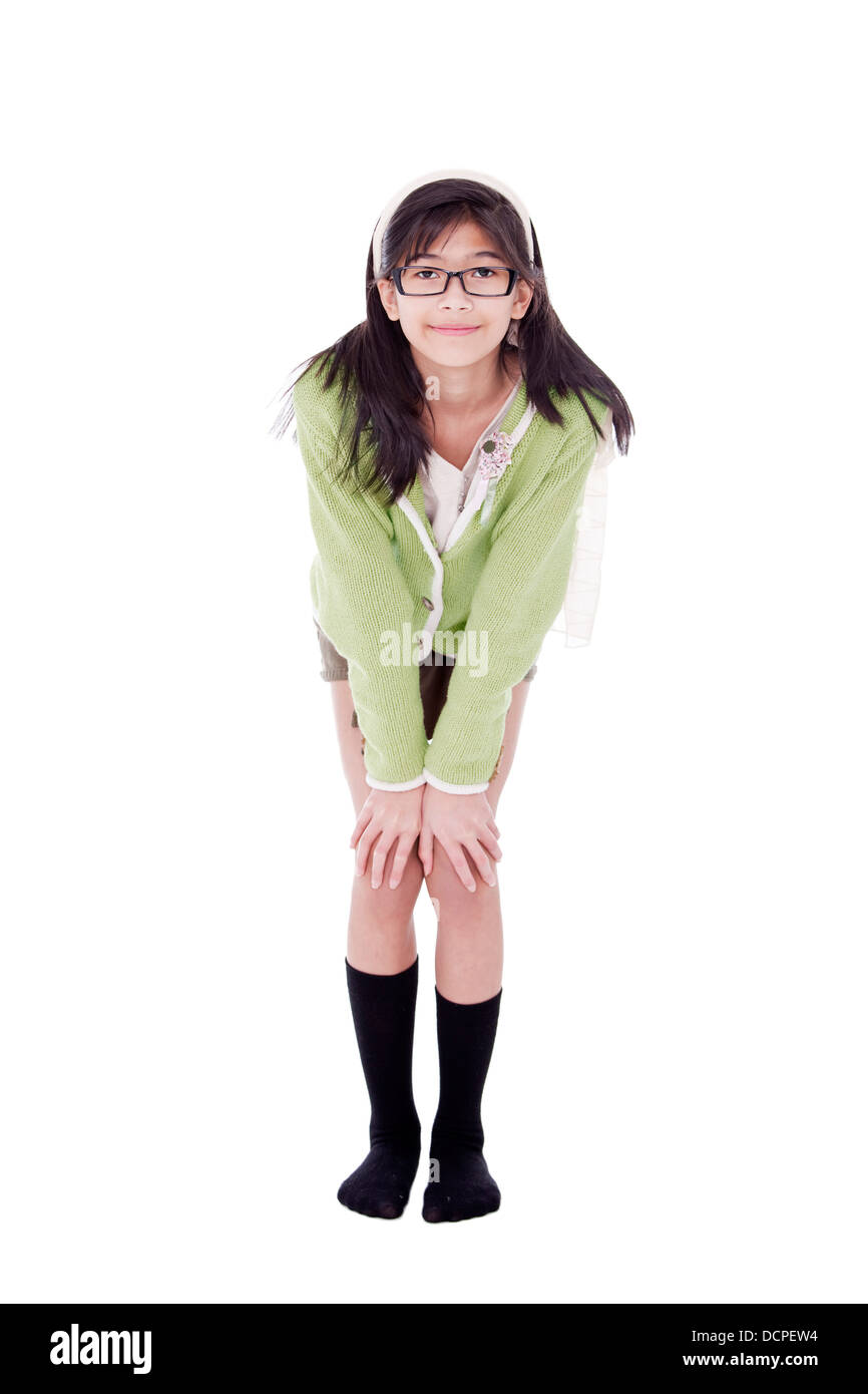 Girl in green sweater and glasses bending forward, hand on knees Stock Photo