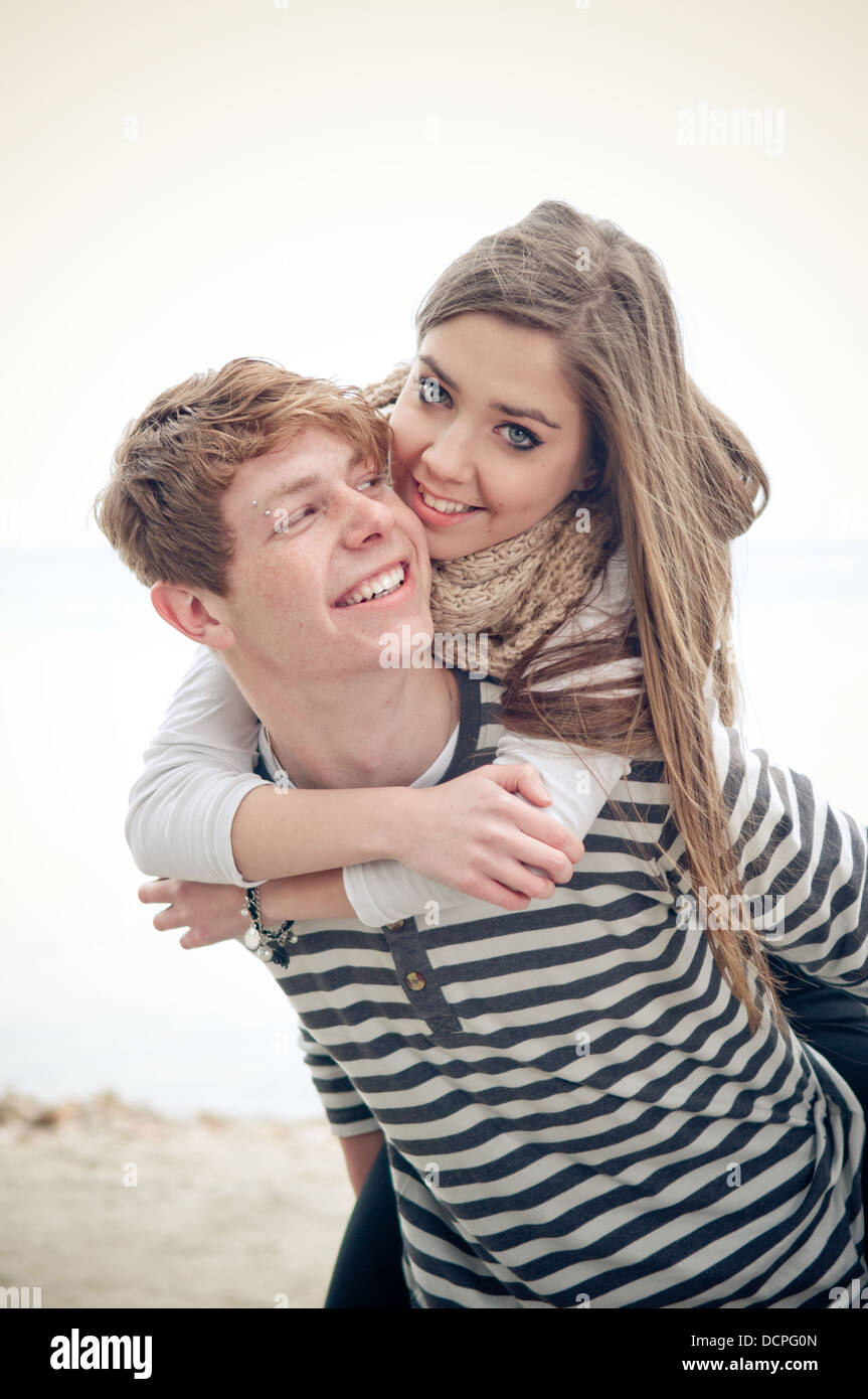 Teenage girl getting a piggyback from her boyfriend Stock Photo
