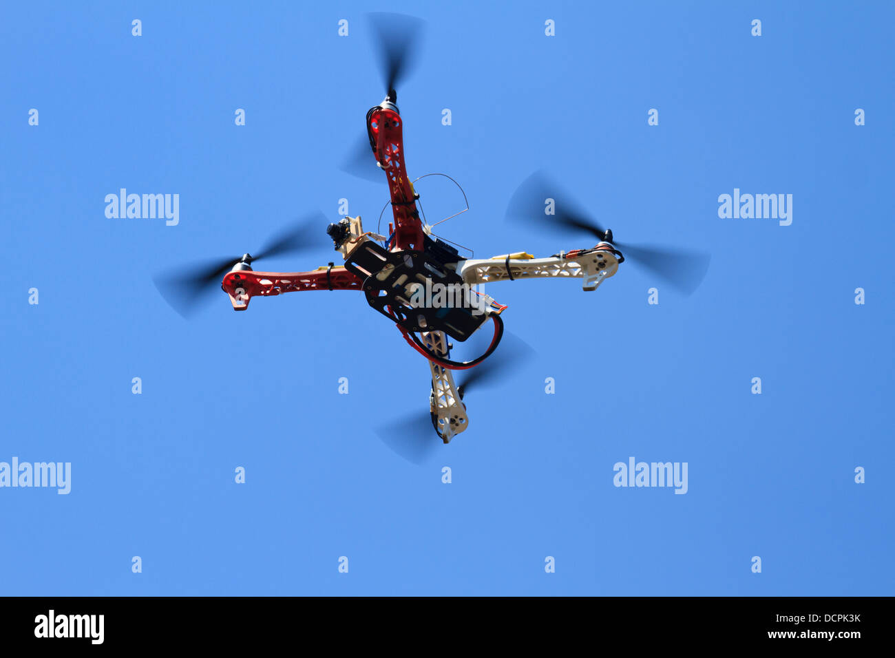 Unmanned Aerial Vehicle (UAV) - Quadcopter with small camera at the air. Stock Photo