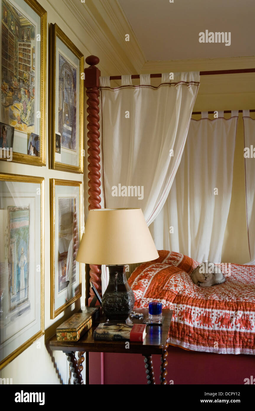 Framed Indian prints in bedroom with custom made fourposter bed with Indian bedcover Stock Photo