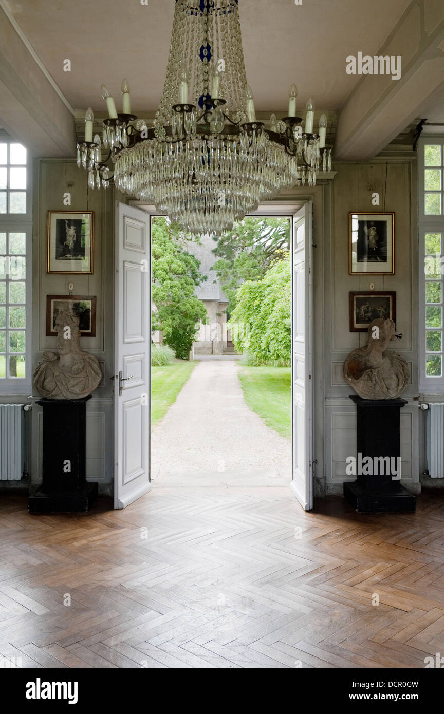 18C chandelier in entrance hall with parquet flooring and stone busts Stock Photo