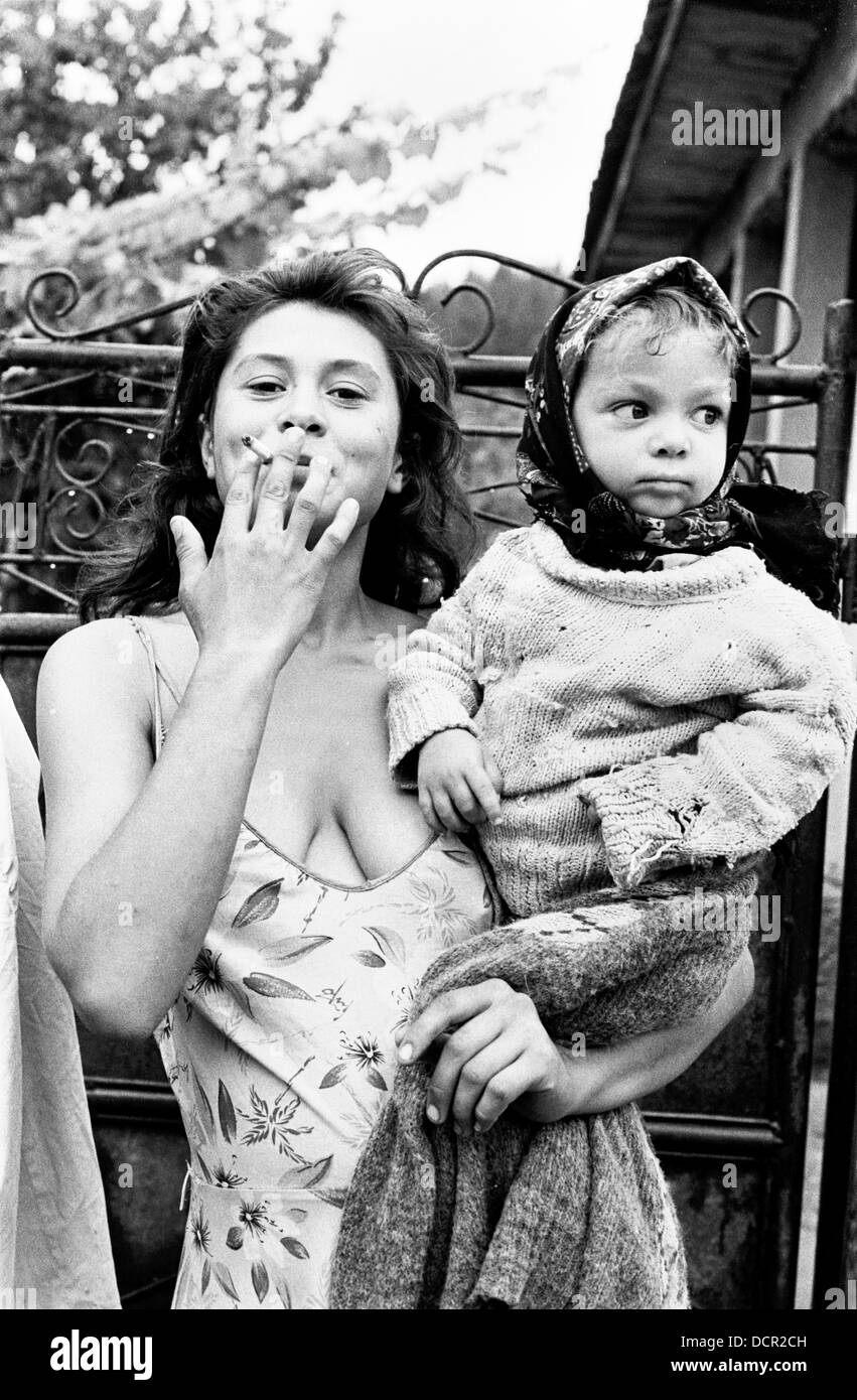 Roma mother smoking and child in Valea Seaca village Bacau Romania Stock Photo