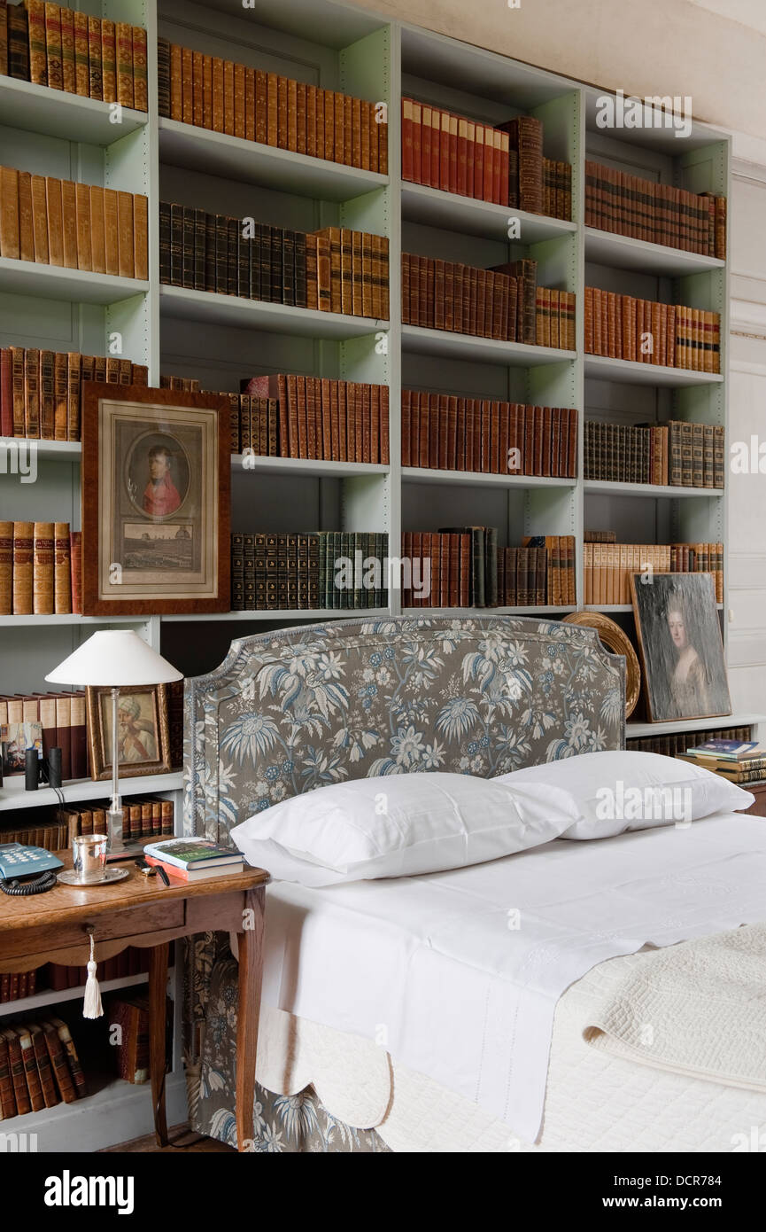 Bookshelves above a bed with a Marvic fabric headboard Stock Photo Alamy