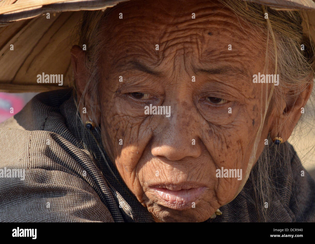 Portrait of an older woman with tarditional hat on a farmer's market on Inle Lake Stock Photo