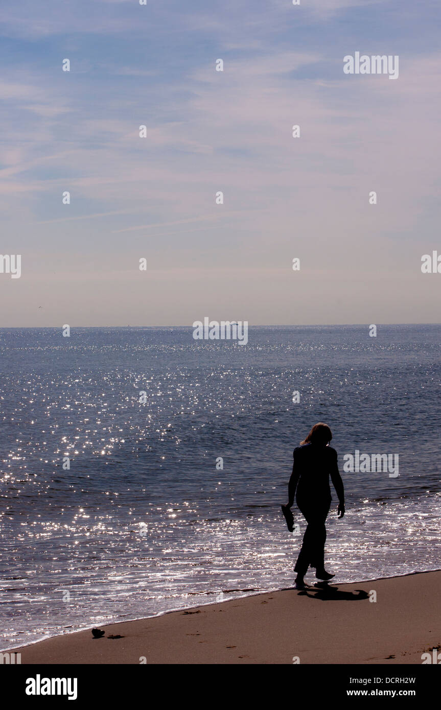 woman walking on beach Norfolk Stock Photo