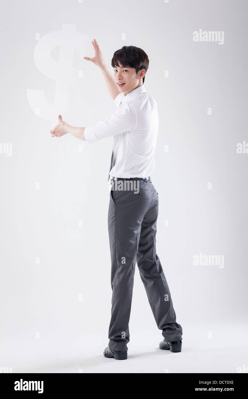 a business man holding a dollar sign Stock Photo - Alamy