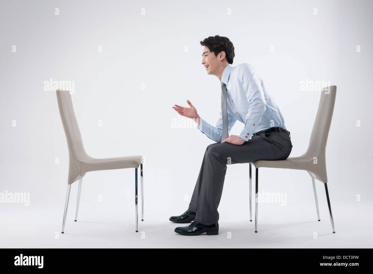 a business man sitting and talking to an empty chair Stock Photo 59536621 Alamy