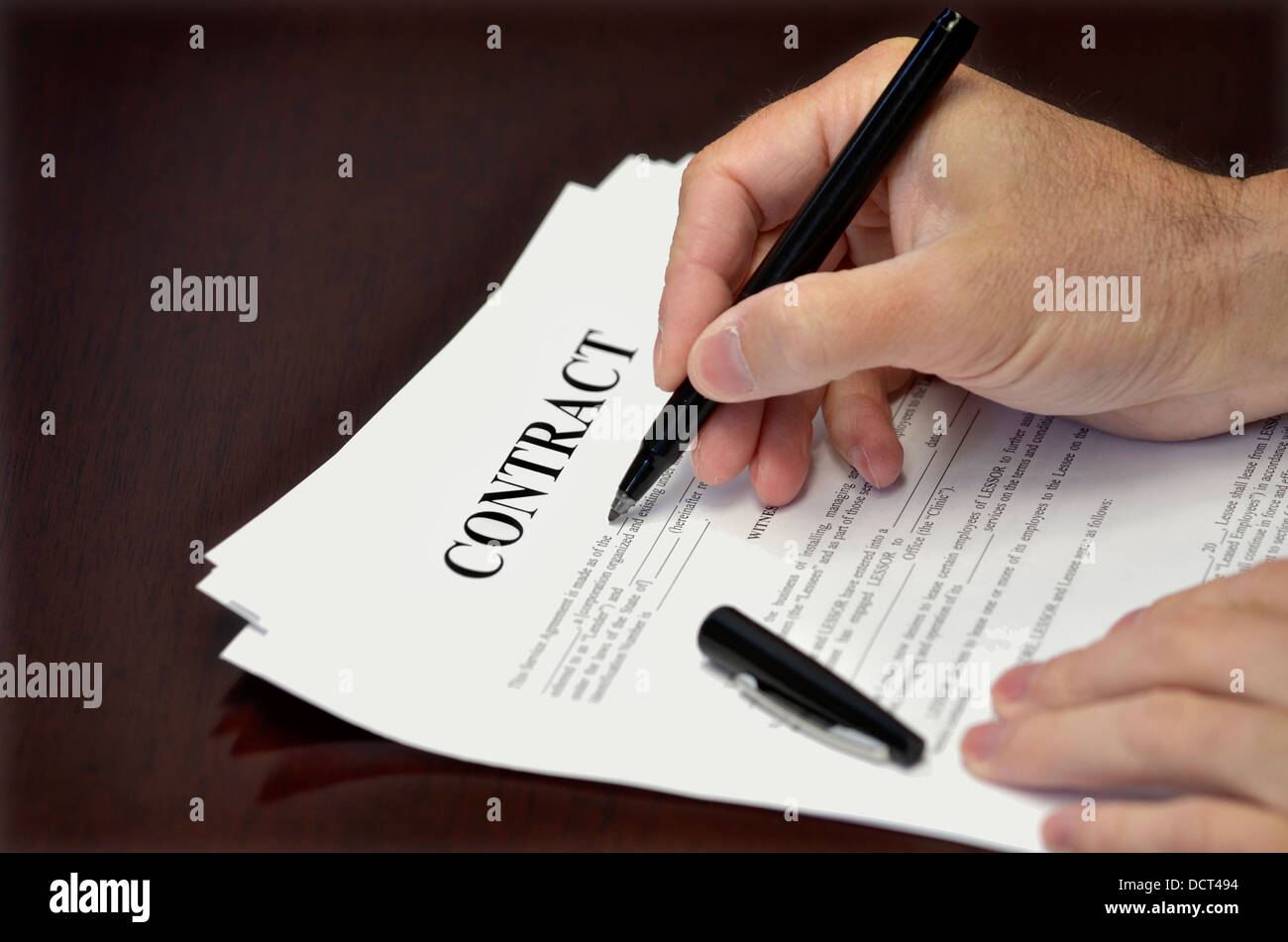 Business man signing contract with black pen on desk Stock Photo