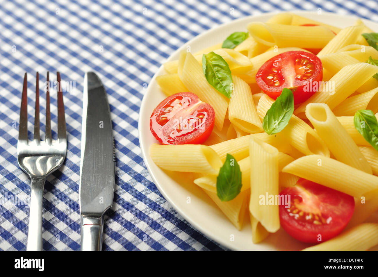 Penne pasta with cherry tomatoes and basil closeup Stock Photo Alamy