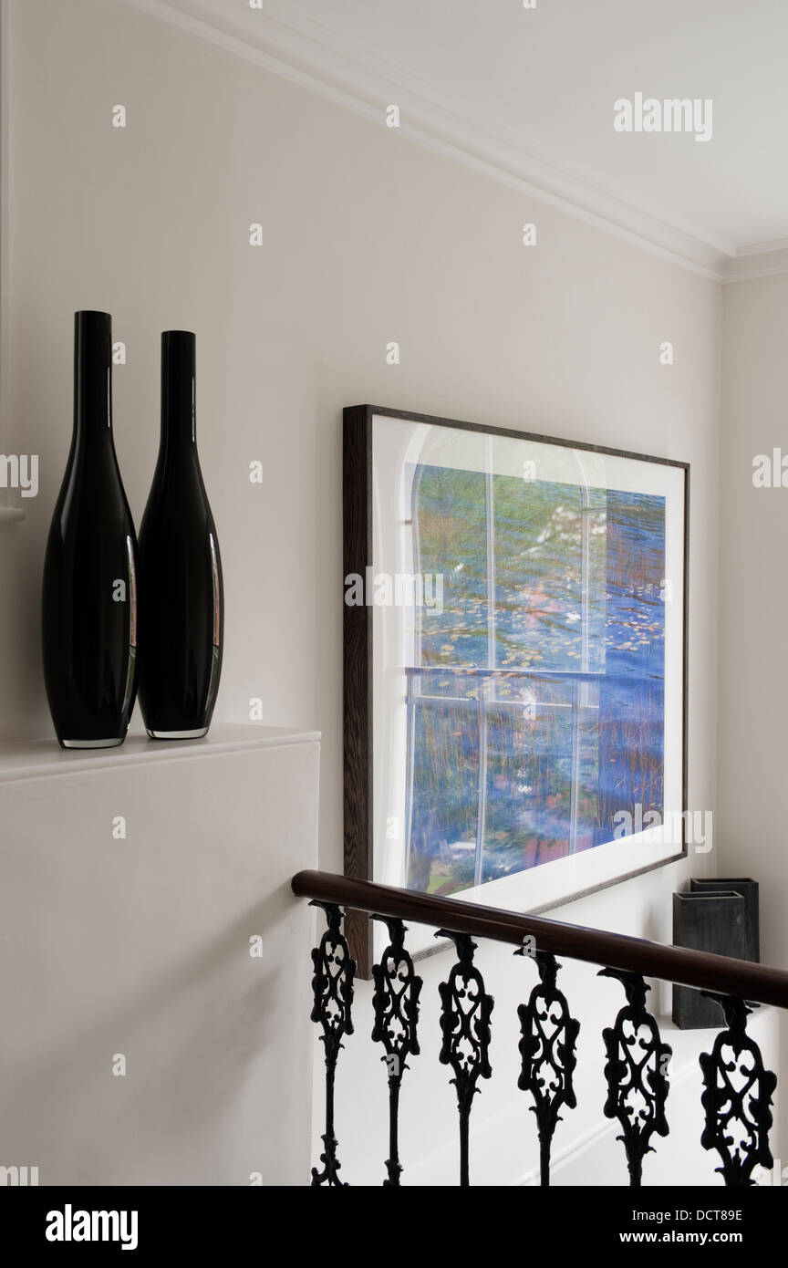 Artwork and handrail with vases in on landing in19th century Kensington home Stock Photo