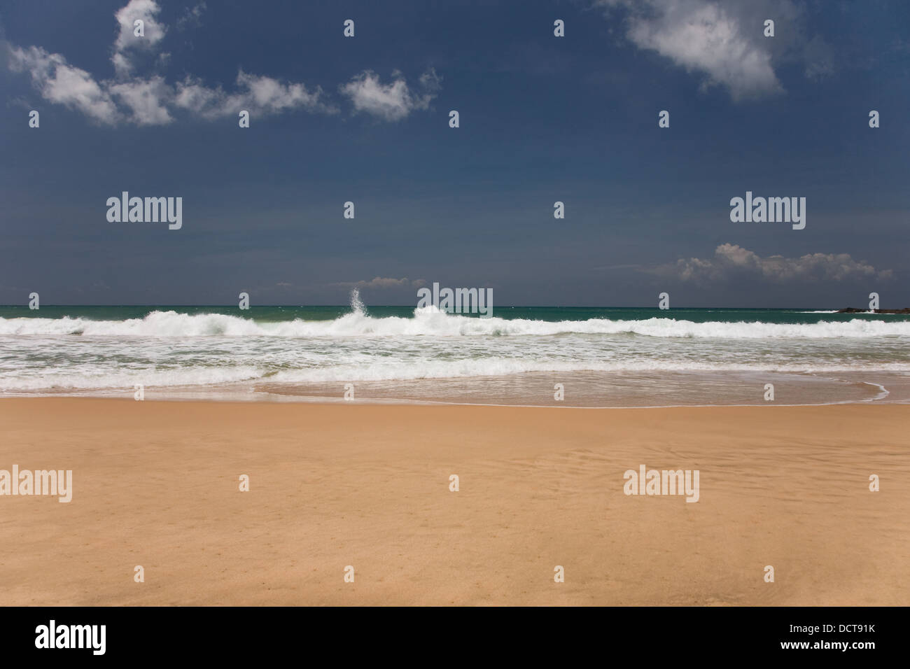 golden sand beach with blue ocean and cloudscape Stock Photo - Alamy
