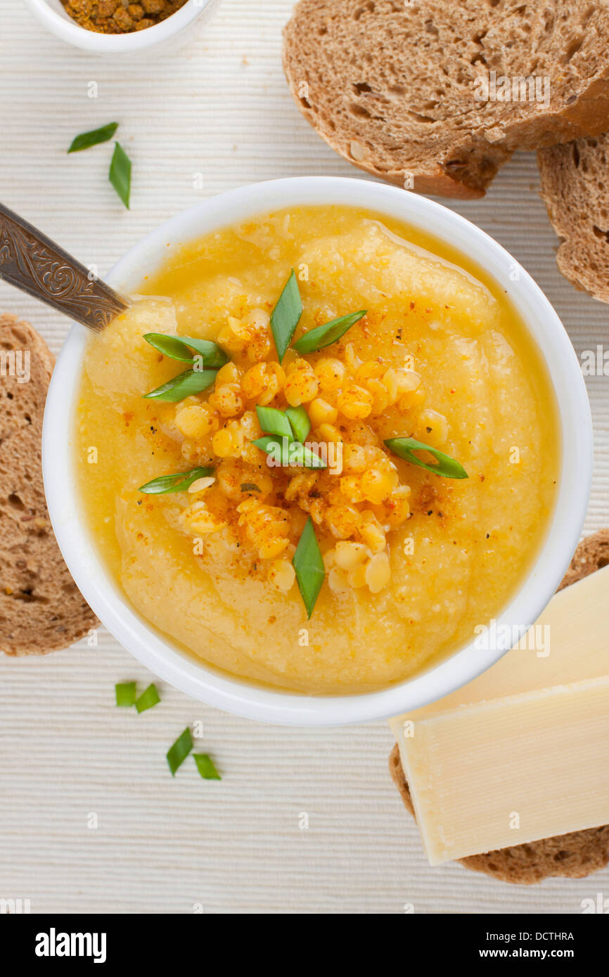 Close up of a portion of pureed yellow lentil soup with chives Stock Photo