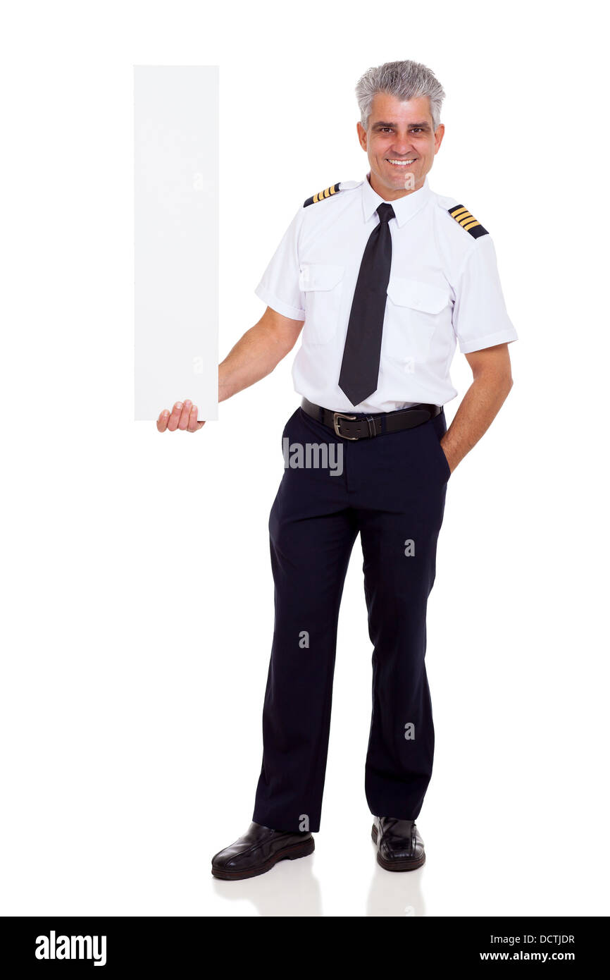 middle aged airline pilot captain holding vertical blank banner on white background Stock Photo