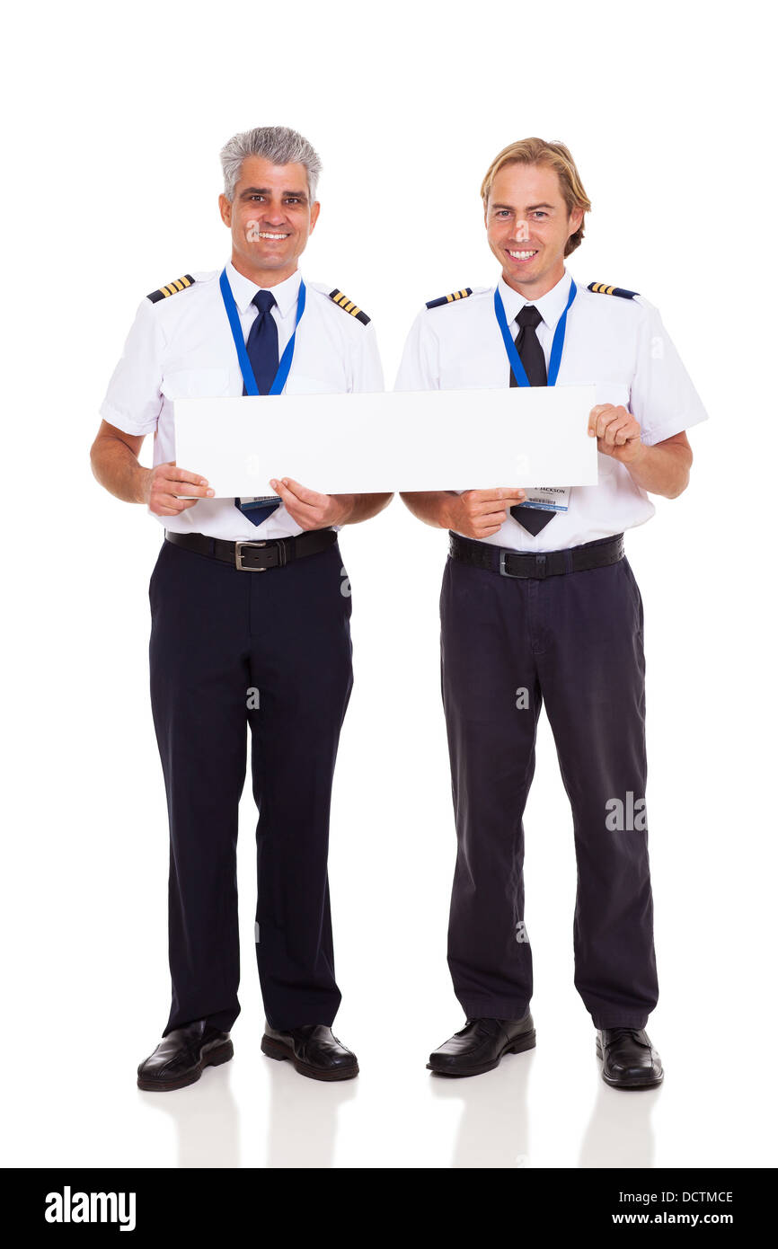 smiling airline pilots holding blank banner on white background Stock Photo