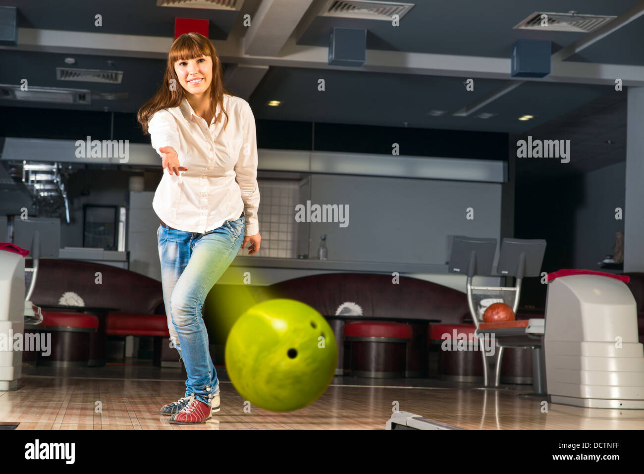 pleasant young woman throws a bowling ball Stock Photo Alamy