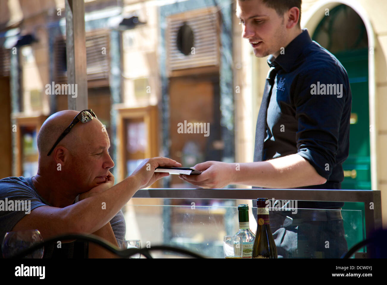 paying bill at cafe Rome Italy Stock Photo