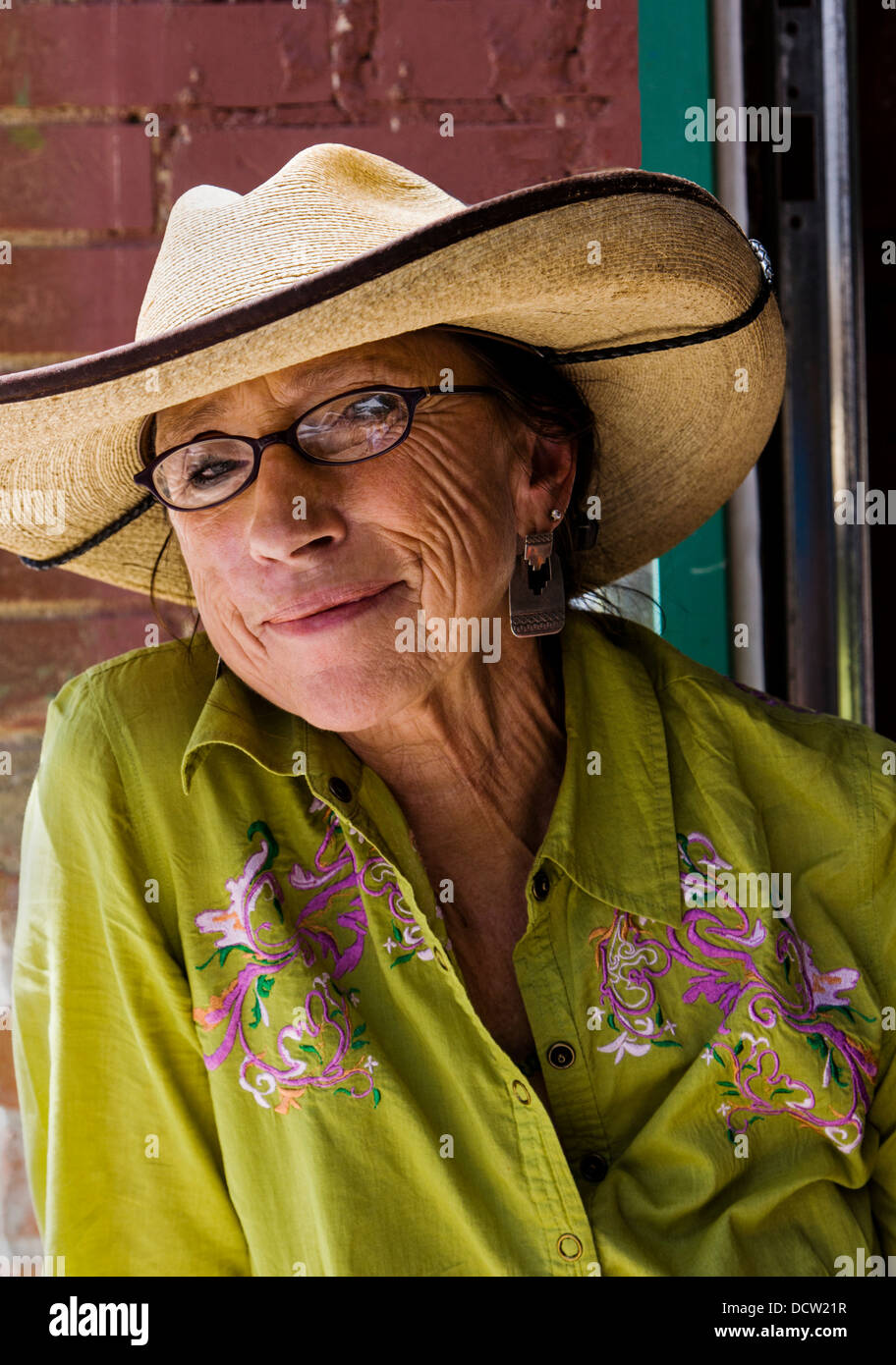 Older ranch woman with weathered face seated at a cafe enjoying warm sunny day, Buena Vista, Colorado, USA Stock Photo