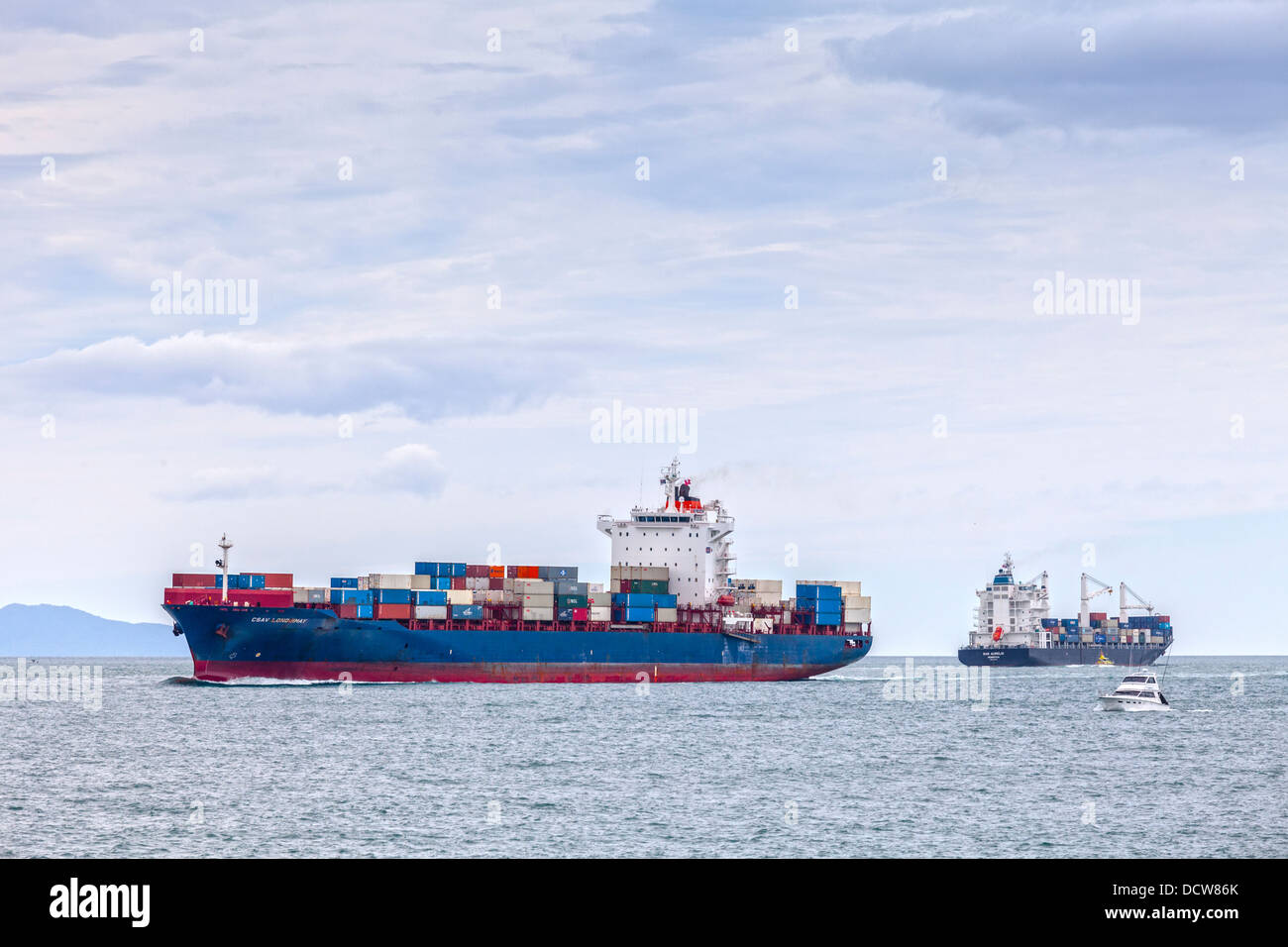 Container ship CSAV Lonquimay coming in to Tauranga Port, New Zealand, as the San Aurelio leaves. Stock Photo