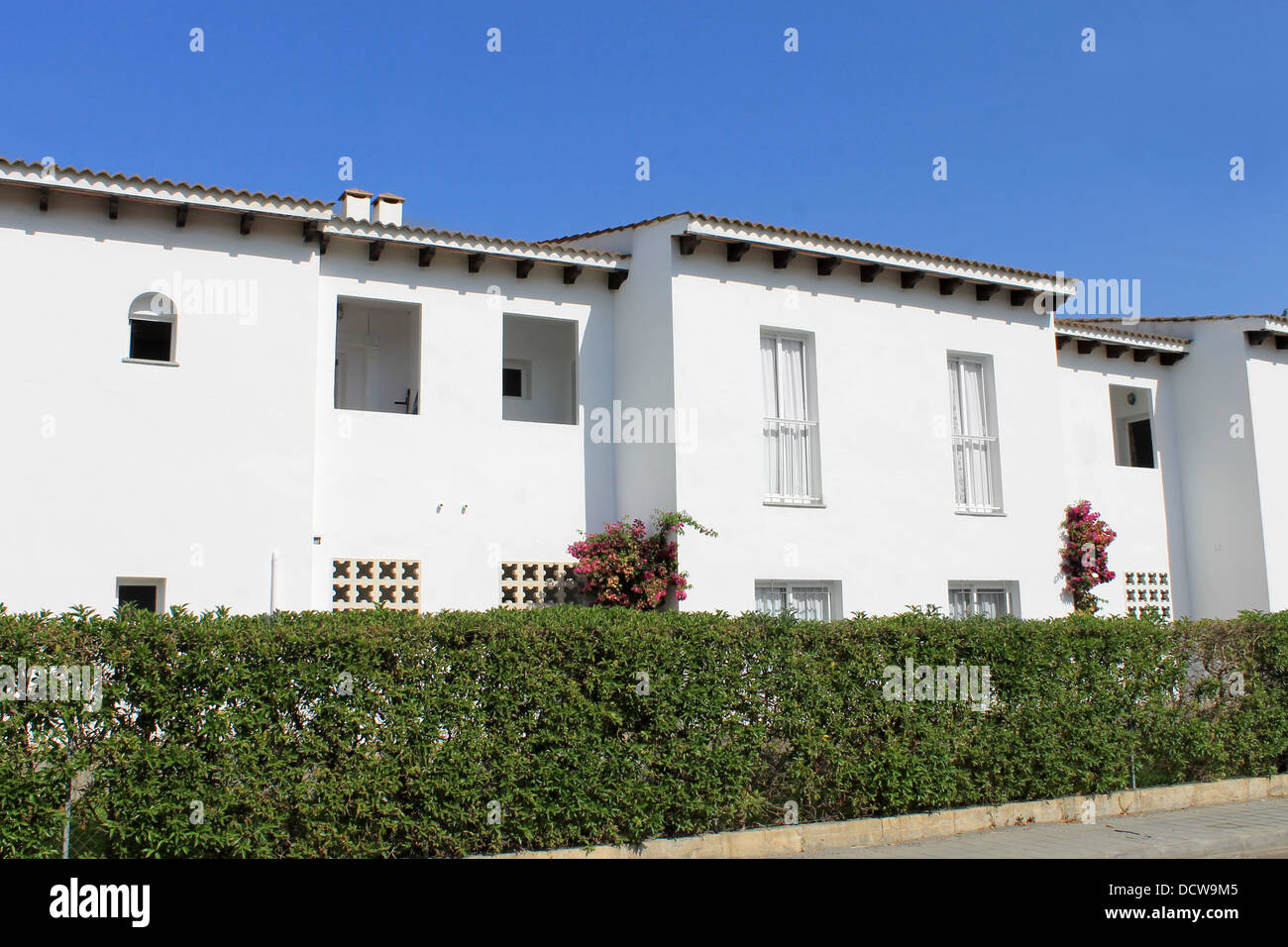 Exterior of white Spanish houses with blue sky background. Stock Photo