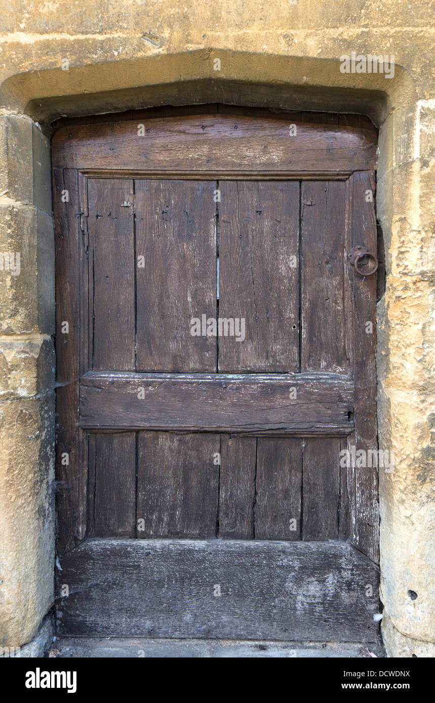 Old wooden door in sandstone doorway, Chipping Campden, Gloucestershire, England, UK Stock Photo
