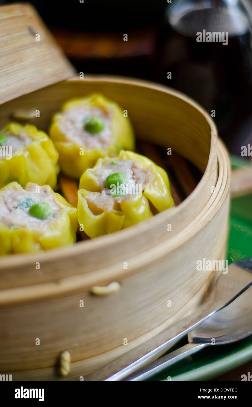 Chicken Sui Mai, a Chinese dish, in a bamboo steamer ready to be served as starters for the meal. Stock Photo