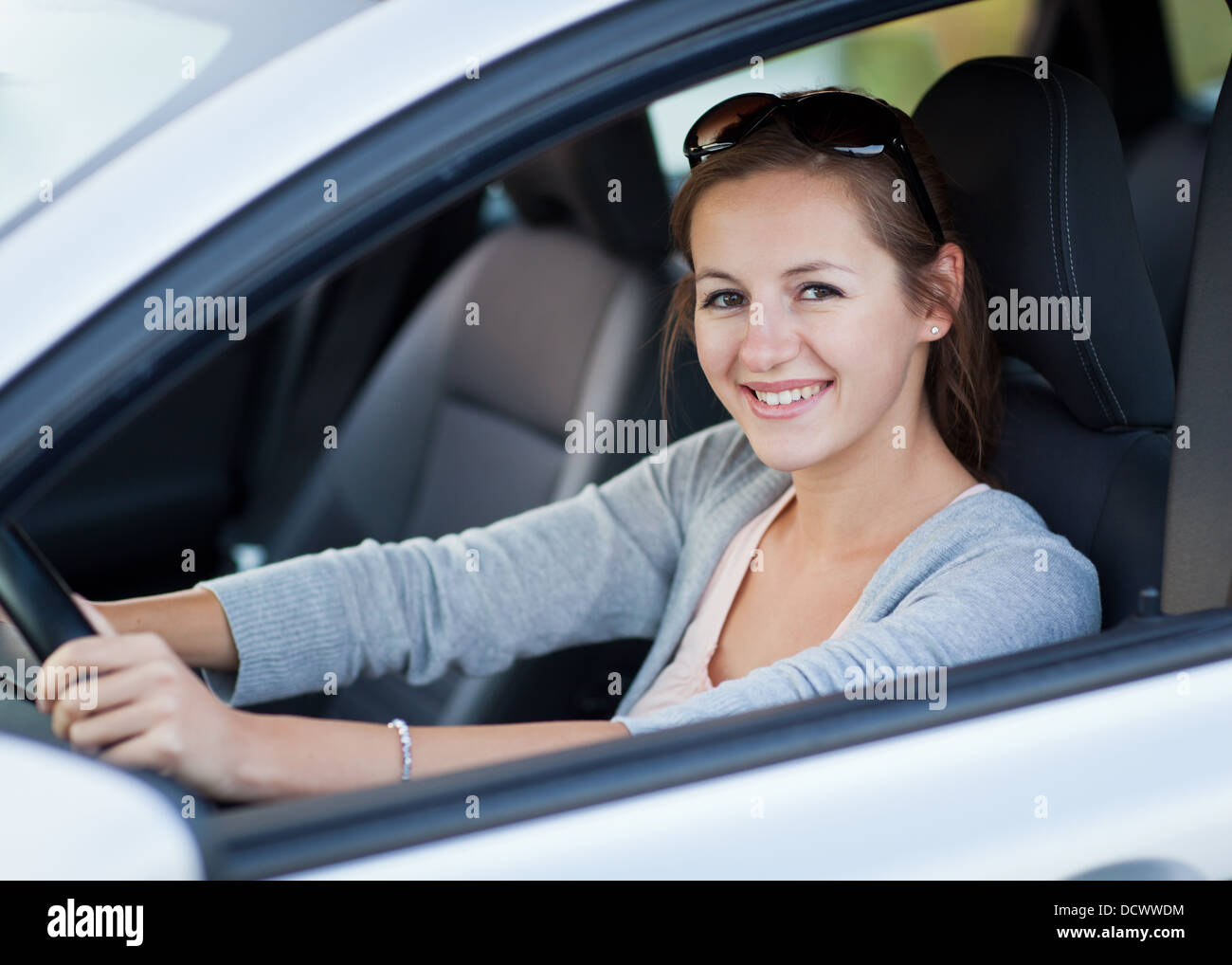 Pretty young woman driving her new car Stock Photo Alamy
