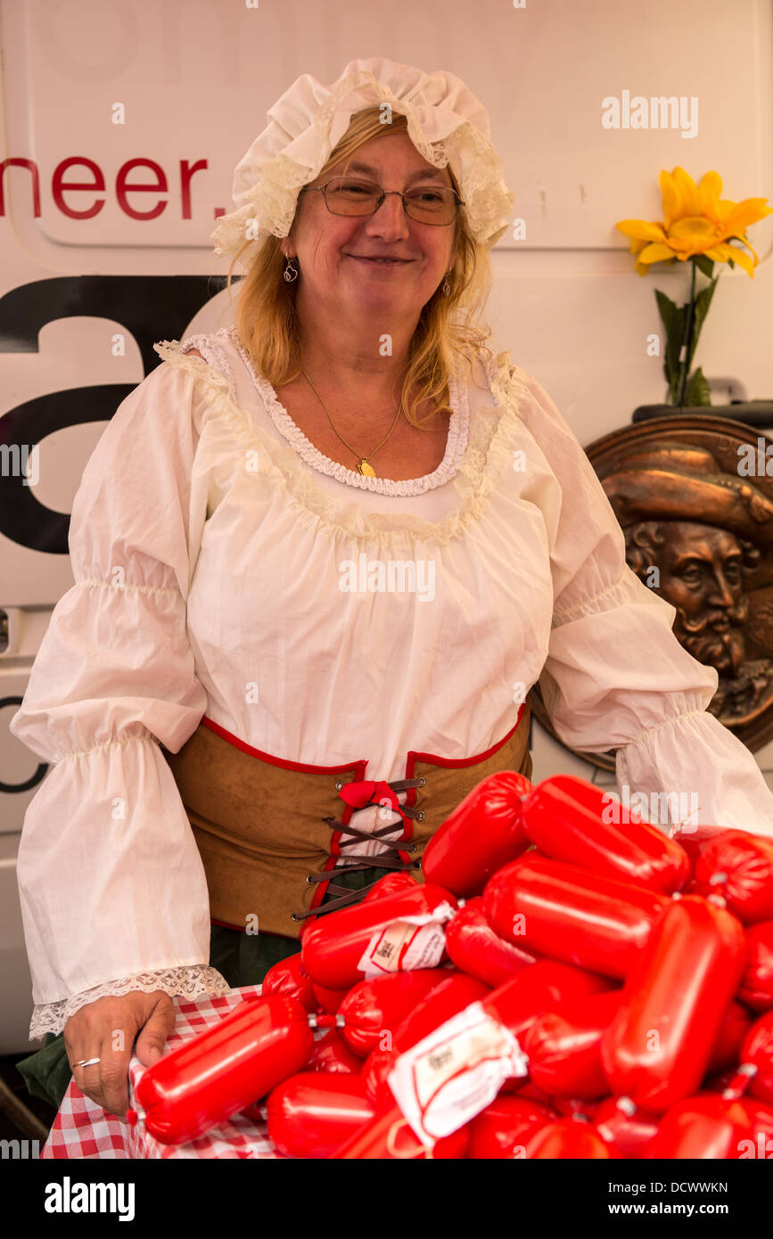 Woman in traditional costume selling sausages at a festival in Antwerp, Belgium Stock Photo