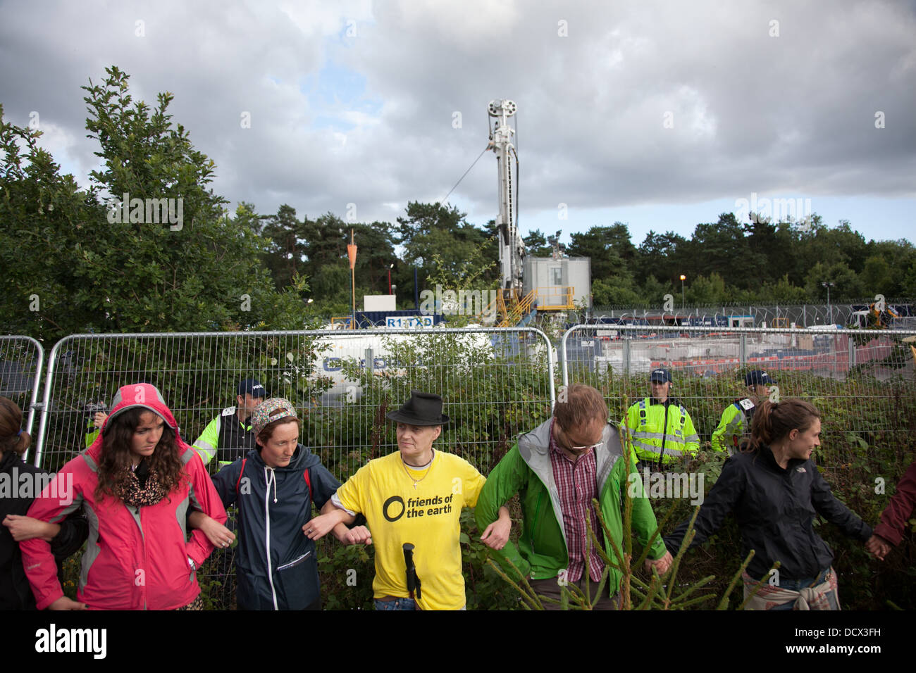 Anti-fracking activists join hands to surround the Cuadrilla fracking site protected by police and G4S security. Stock Photo