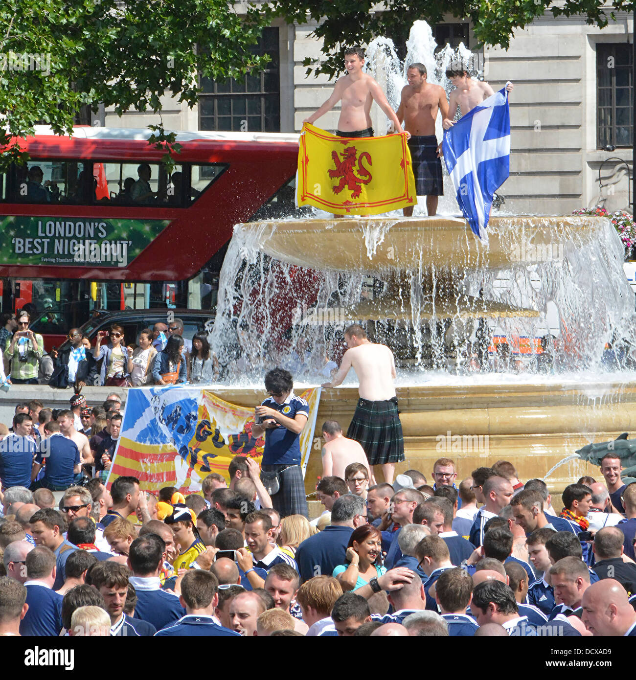Scottish football fans climb top of Trafalgar Square fountain people stop off in London before match between England Scotland team Wembley England UK Stock Photo