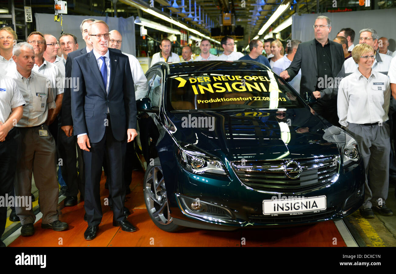 Karl-Thomas Neumann (L), Adam Opel AG chairman of the board,  and Opel employees stand next to the first Opel Insignia Sports Tourer to be sold, at the Opel plant in Ruesselsheim, Germany, 22 August 2013. The car manufacturer has revised its nearly five-year-old flagship. The second Insignia generation - with a new design, new engines and a revised suspension - will be presented to the public at the IAA motor show in September. Photo: ARNE DEDERT Stock Photo