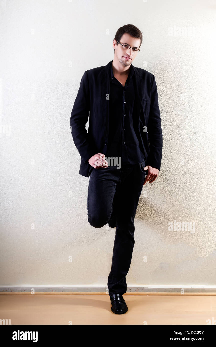 View of a young man standing against a white wall Stock Photo - Alamy