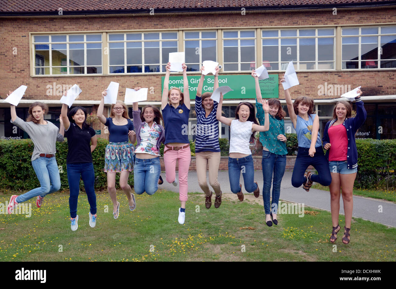 A group of happy students jumping in the air while holding their ...