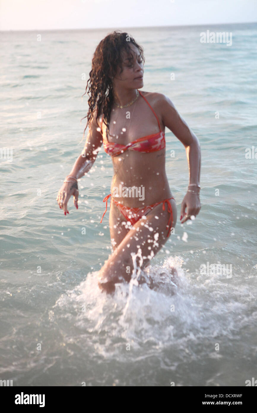 Rihanna walks back to the beach after swimming in the sea wearing a skimpy  orange bikini The sexy singer is spending her Christmas vacation with her  family in her native country Barbados -