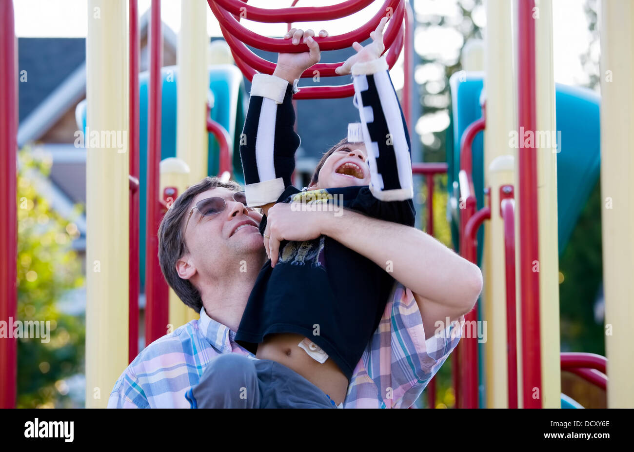 Active disabled five year old boy playing on the  monkey bars wi Stock Photo