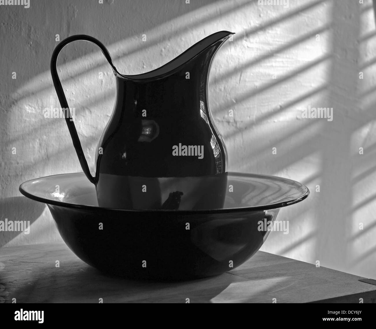 A Black and White Picture of a Jug and Bowl in a Bathroom. Stock Photo