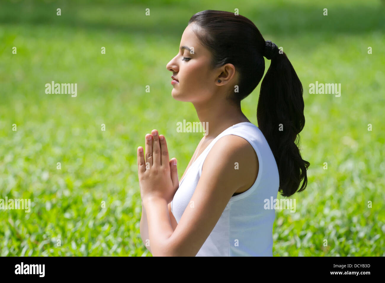 Young woman with hands in prayer position Stock Photo - Alamy
