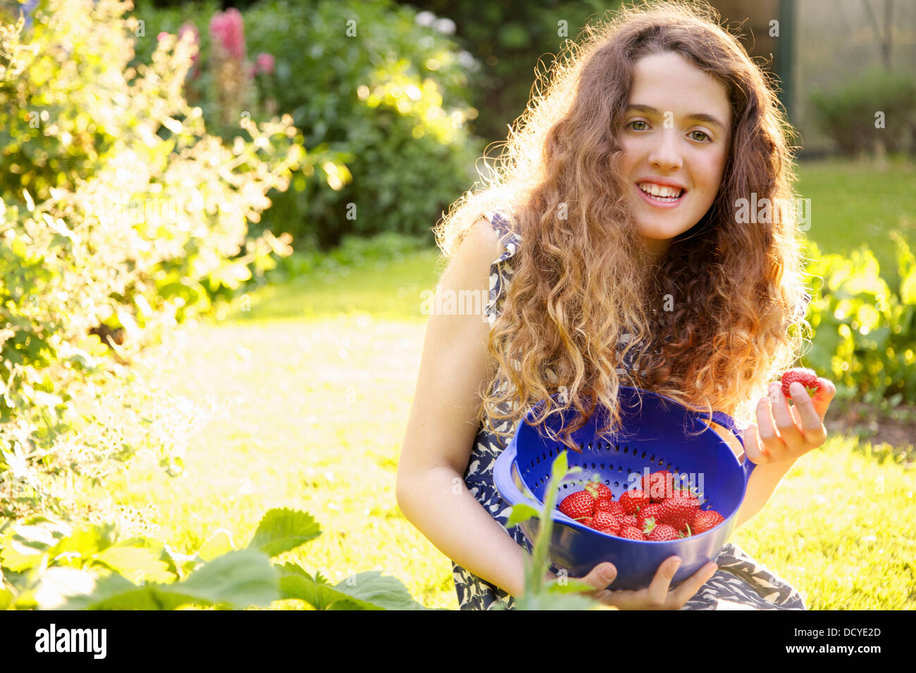 Smiling Teenage Girl Picking Strawberries in Garden Stock Photo - Alamy