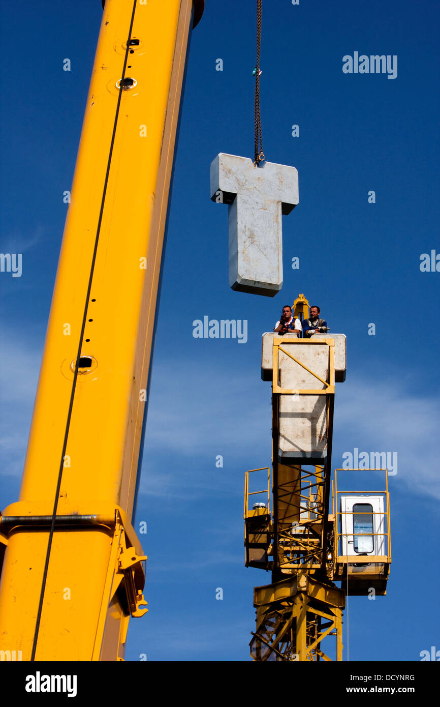 assembly crane lifting cement block counterweights into position Stock