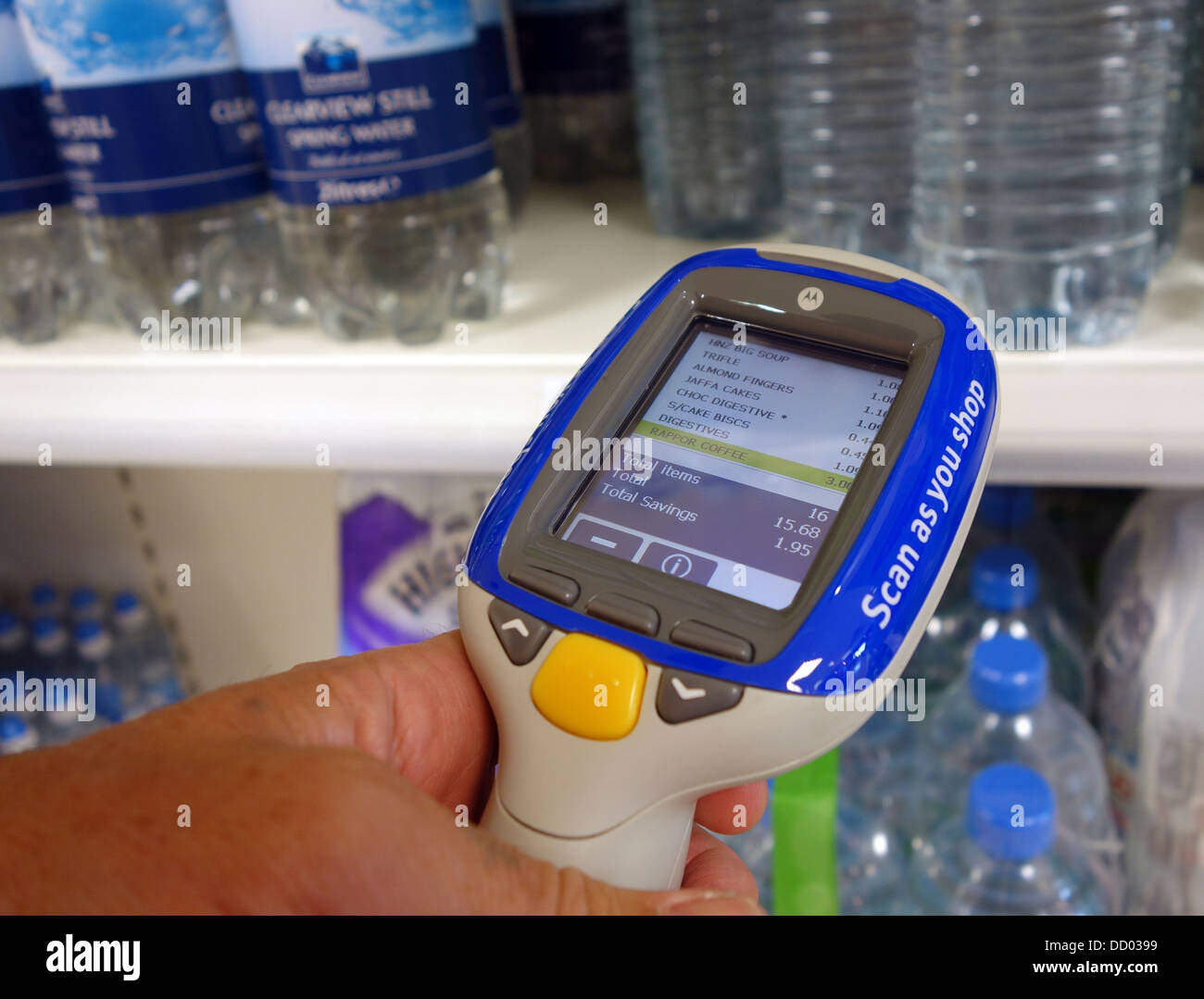 A customer using a ' scan as you shop ' scanner in a Tesco store, UK Stock Photo